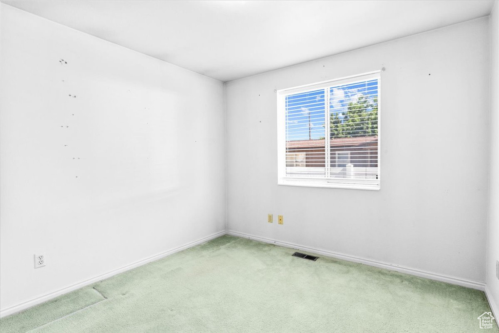 Spare room with light carpet and baseboards