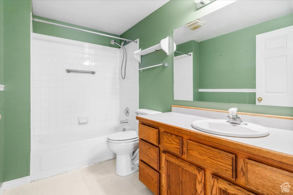 Bathroom with vanity, shower / bath combination, and tile patterned floors
