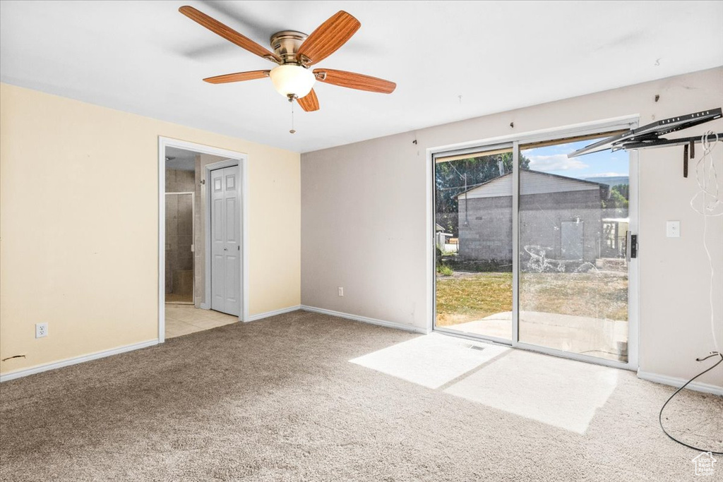 Unfurnished bedroom featuring access to exterior, carpet floors, ensuite bath, and a ceiling fan