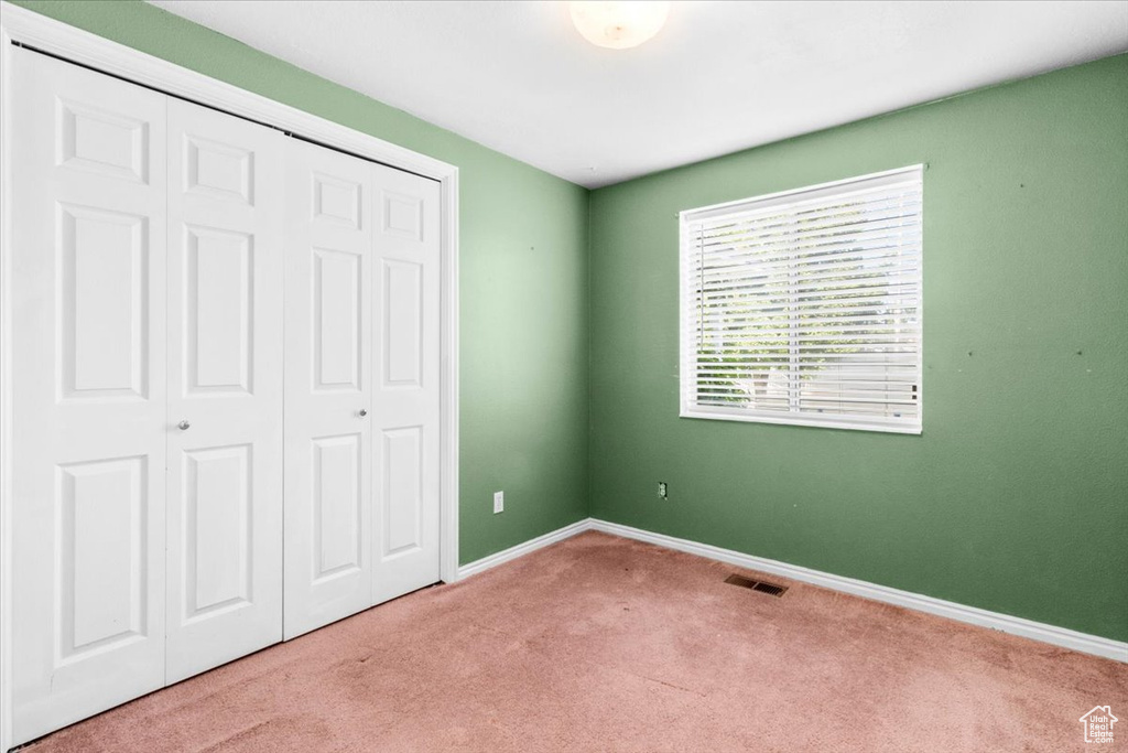 Unfurnished bedroom with carpet and a closet