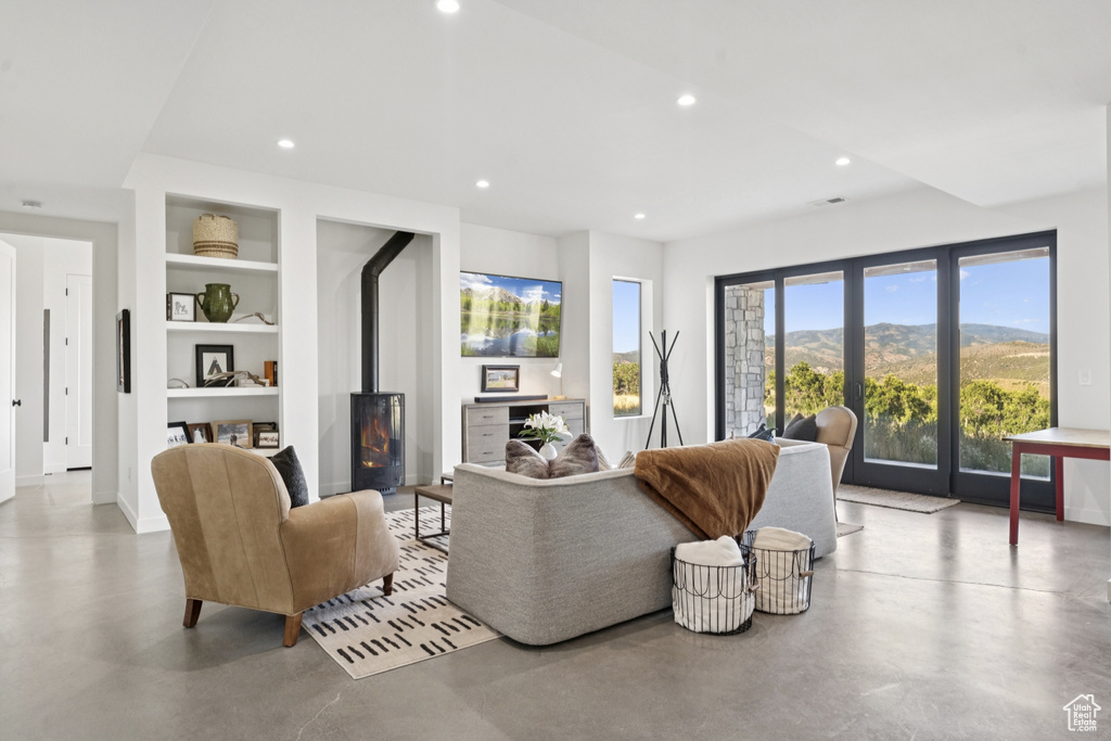 Living room featuring finished concrete floors, built in features, and recessed lighting