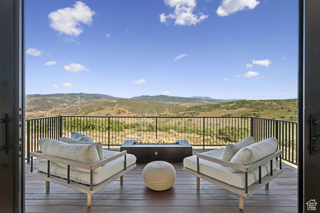 Deck with a mountain view and an outdoor living space with a fire pit