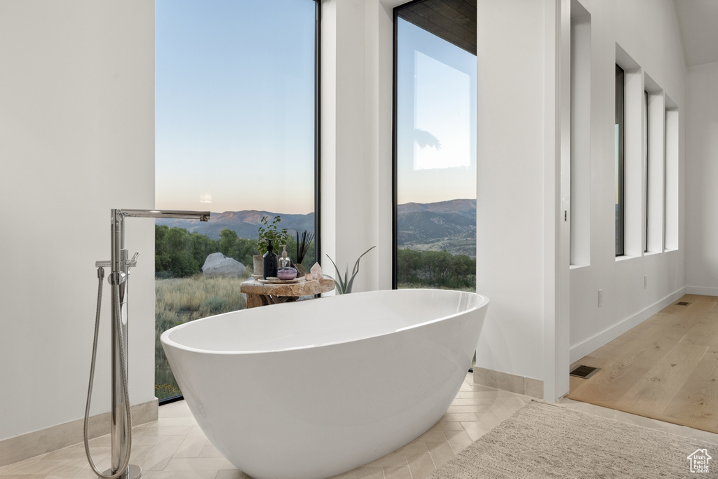 Full bathroom with a soaking tub and baseboards