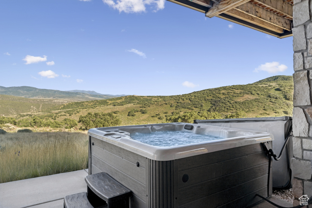 View of patio / terrace featuring a hot tub and a mountain view