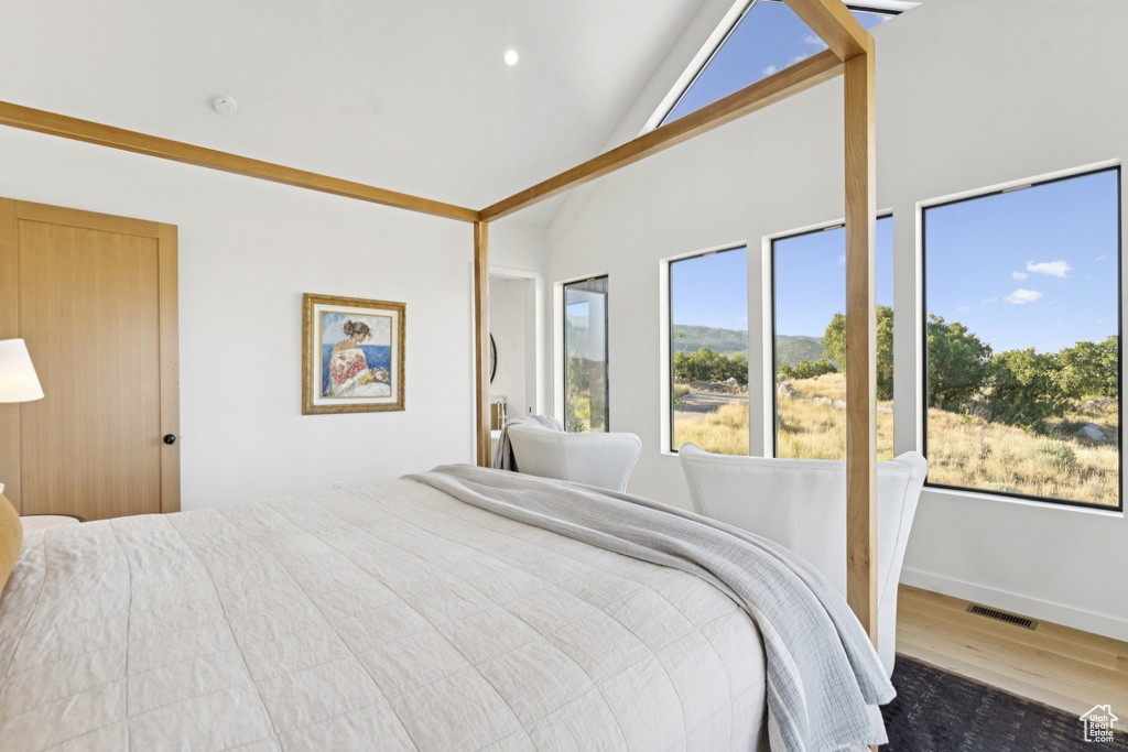 Bedroom with wood finished floors and high vaulted ceiling