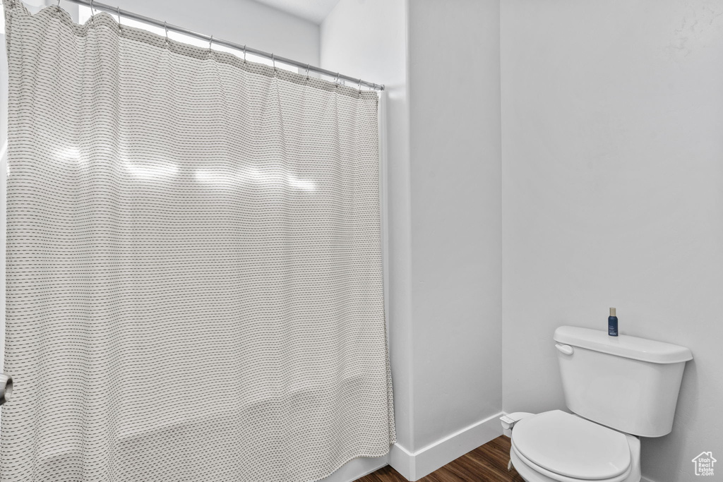 Full bathroom with wood finished floors and a shower with curtain