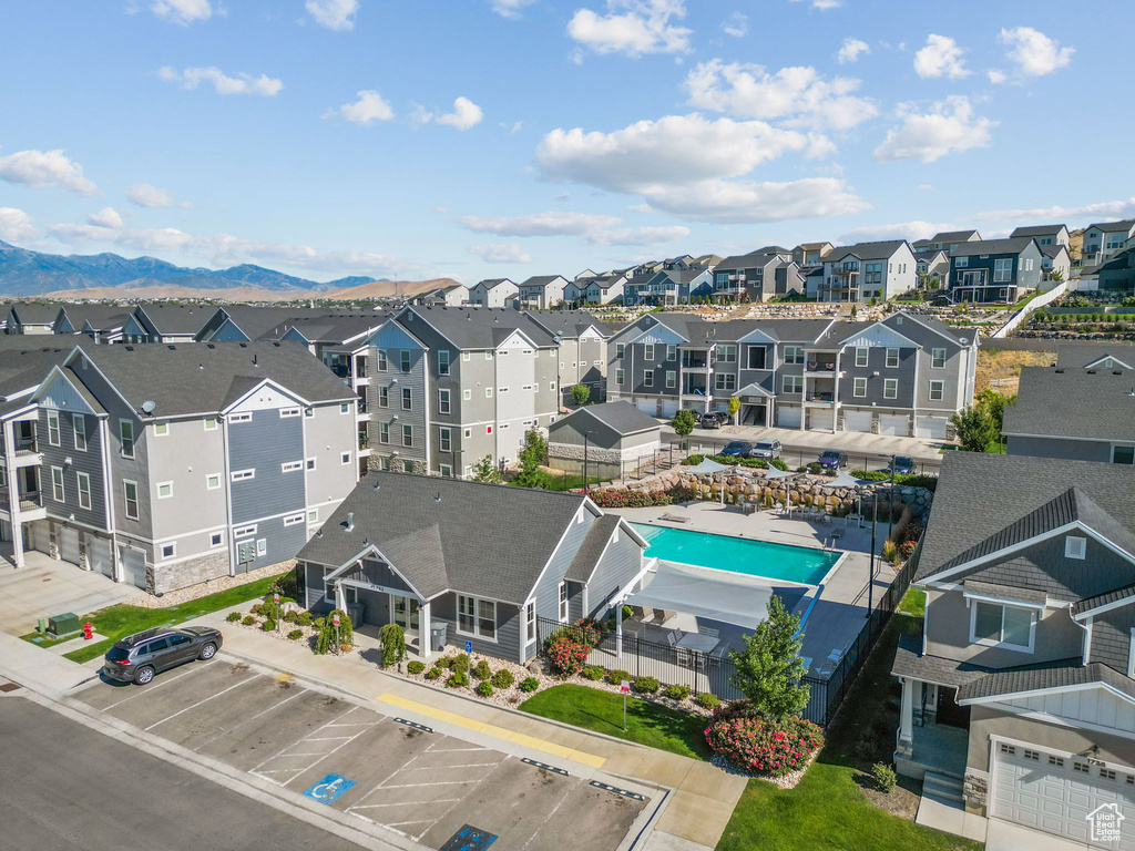 Aerial view of residential area featuring a pool and a mountainous background