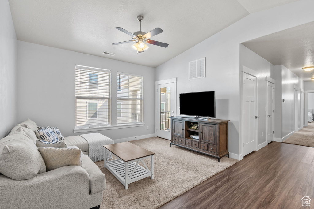 Living area featuring ceiling fan, wood finished floors, and vaulted ceiling