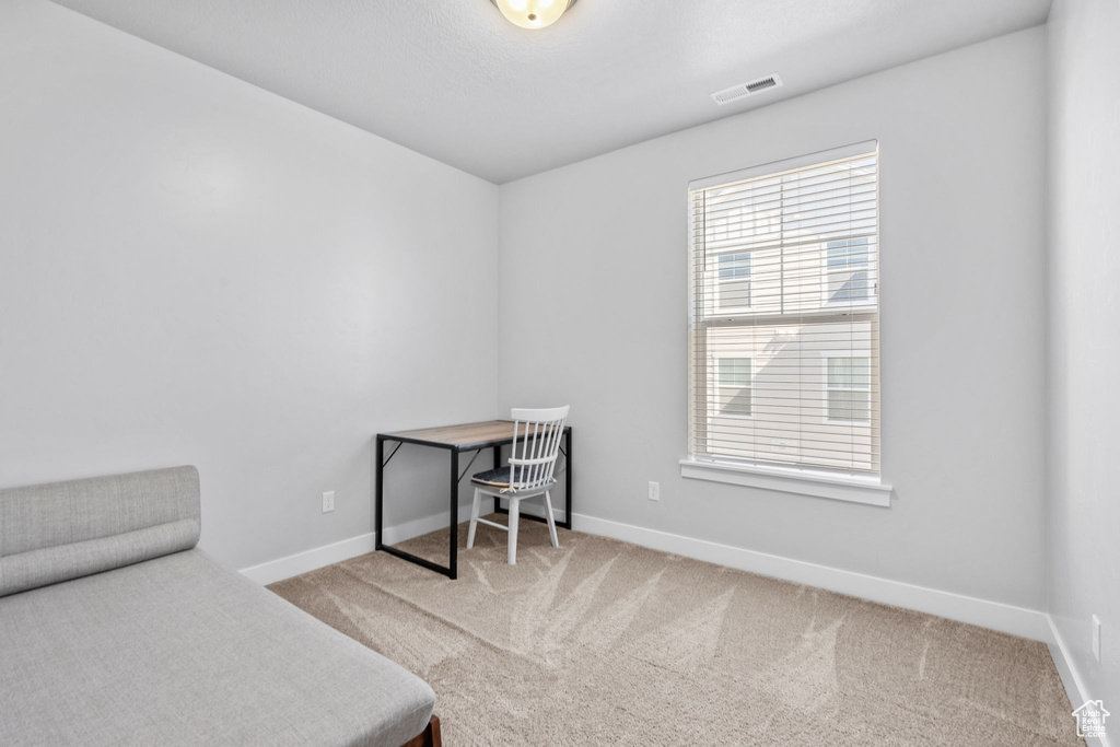 Carpeted home office featuring baseboards