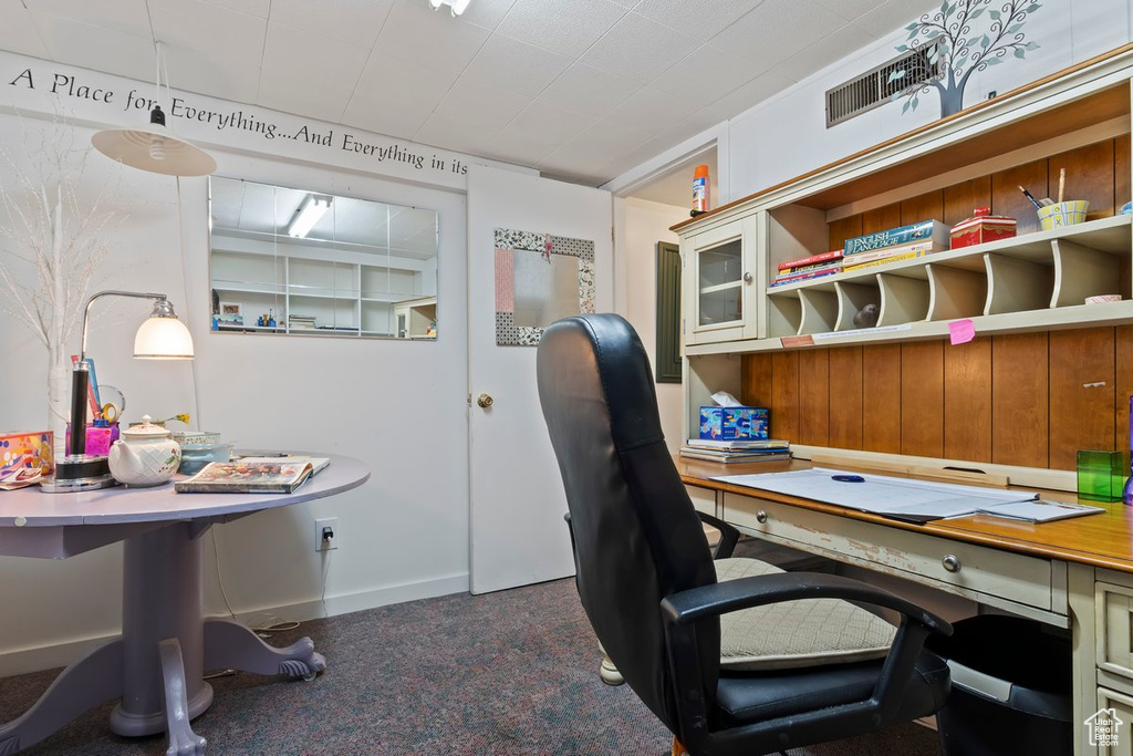 Carpeted home office featuring baseboards