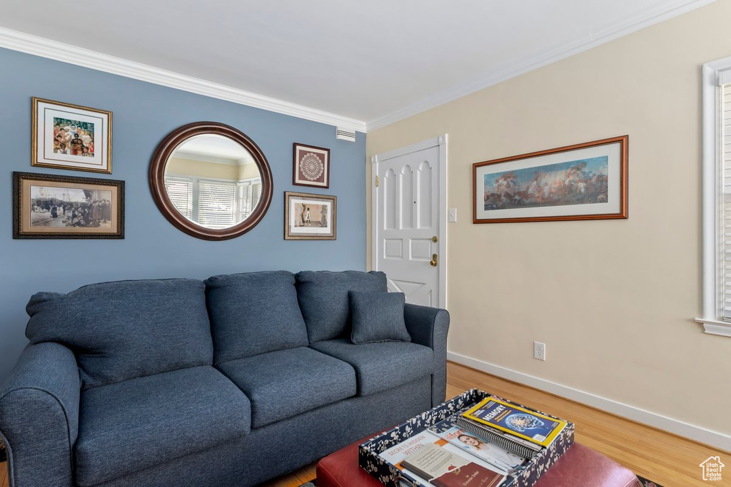 Living area featuring wood finished floors and crown molding