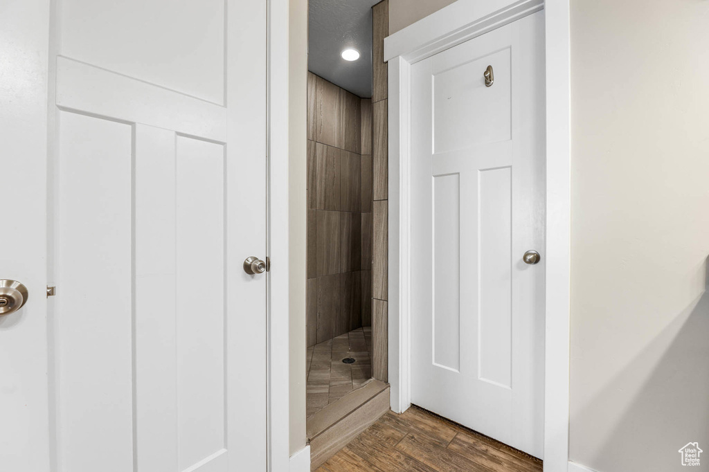 Full bathroom featuring a shower stall and wood finished floors