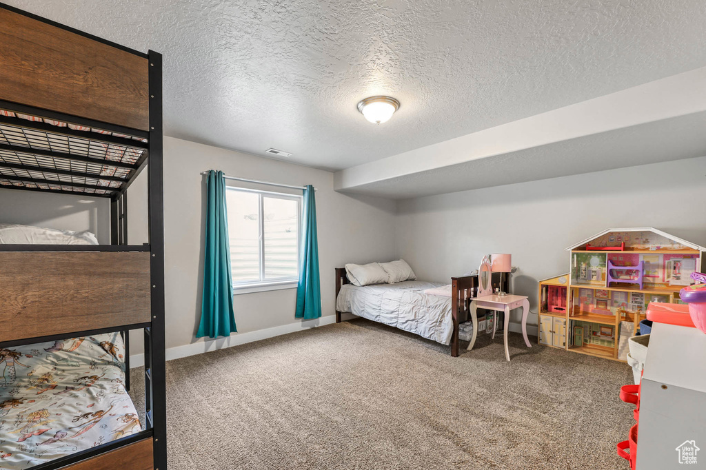 Bedroom with carpet and a textured ceiling