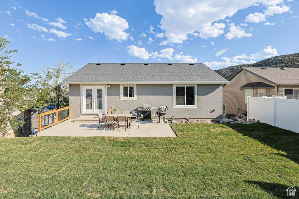Back of property with french doors, stucco siding, a fenced backyard, and a patio