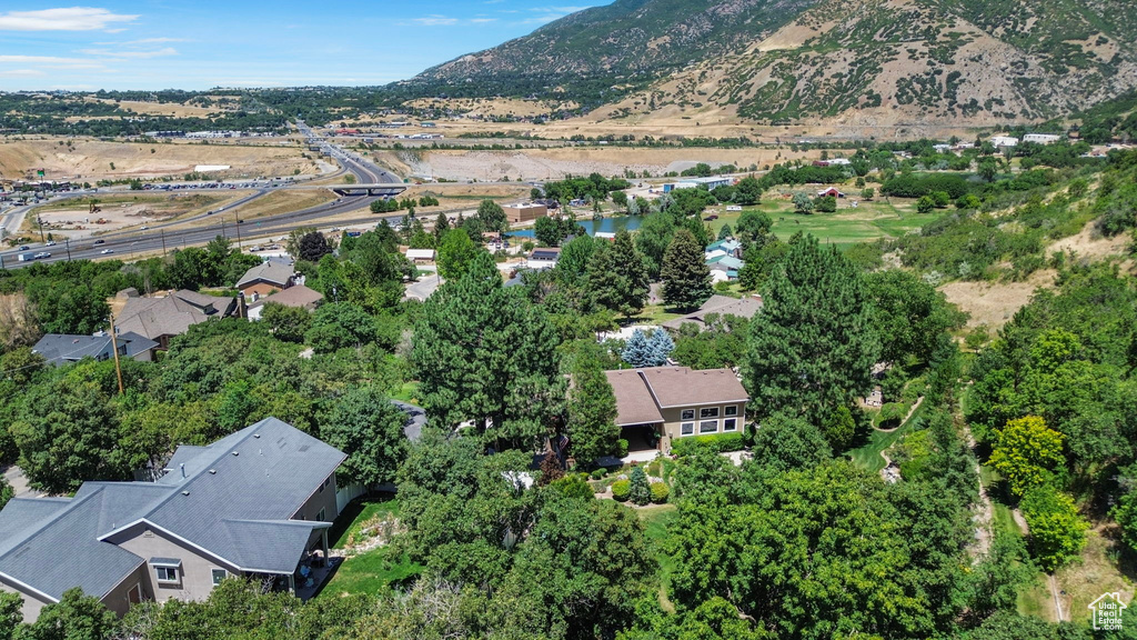 Aerial view of property and surrounding area featuring a mountain backdrop