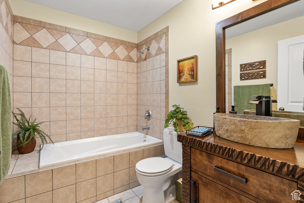 Bathroom with vanity, tile patterned flooring, and tiled shower / bath combo
