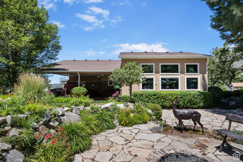 Back of property with a patio and stucco siding
