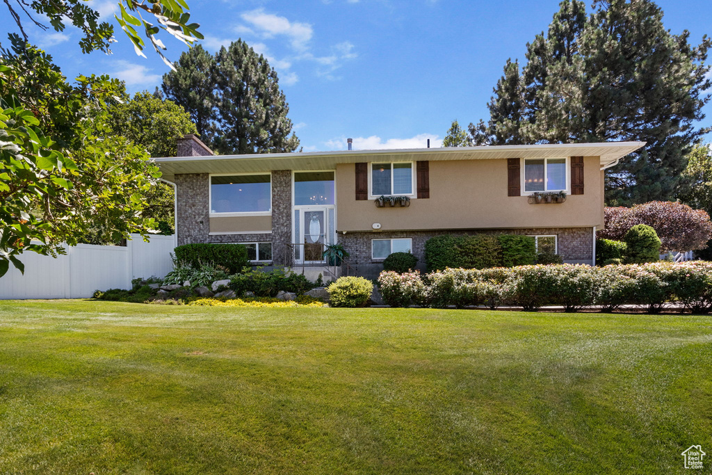 Split foyer home featuring brick siding and stucco siding