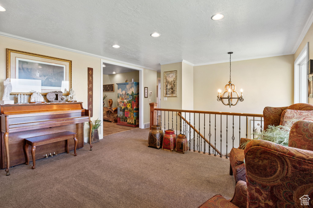 Sitting room with a chandelier, carpet flooring, an upstairs landing, ornamental molding, and recessed lighting