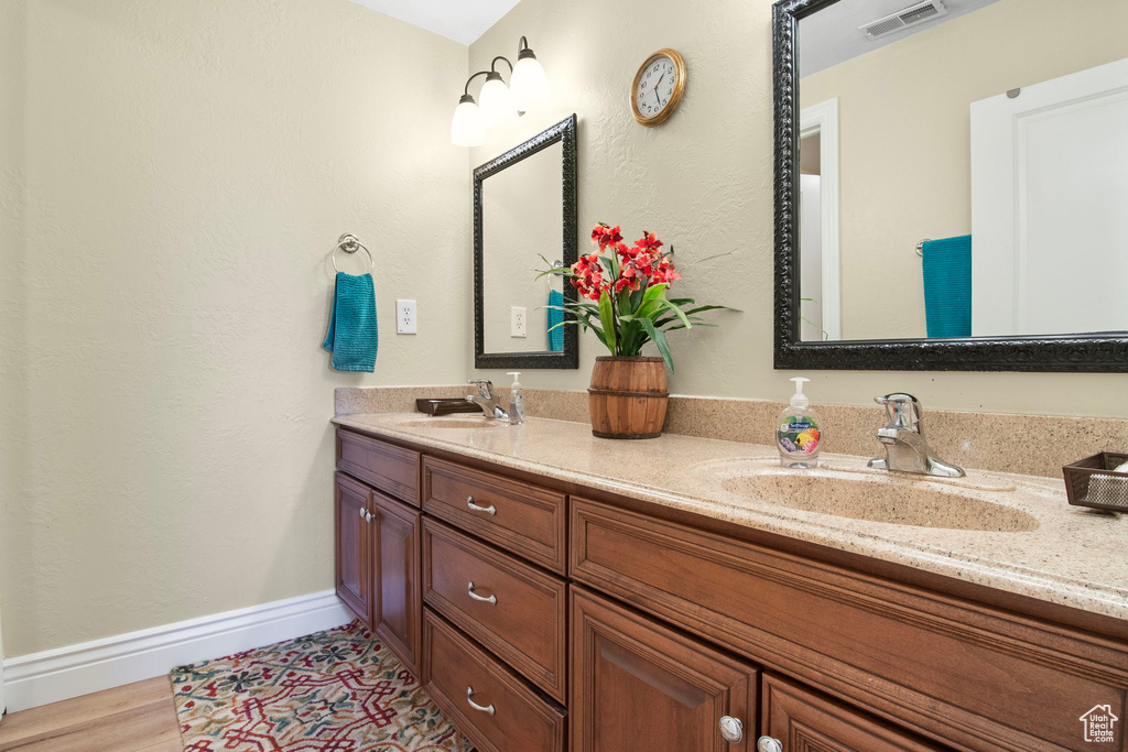 Full bath with double vanity and baseboards