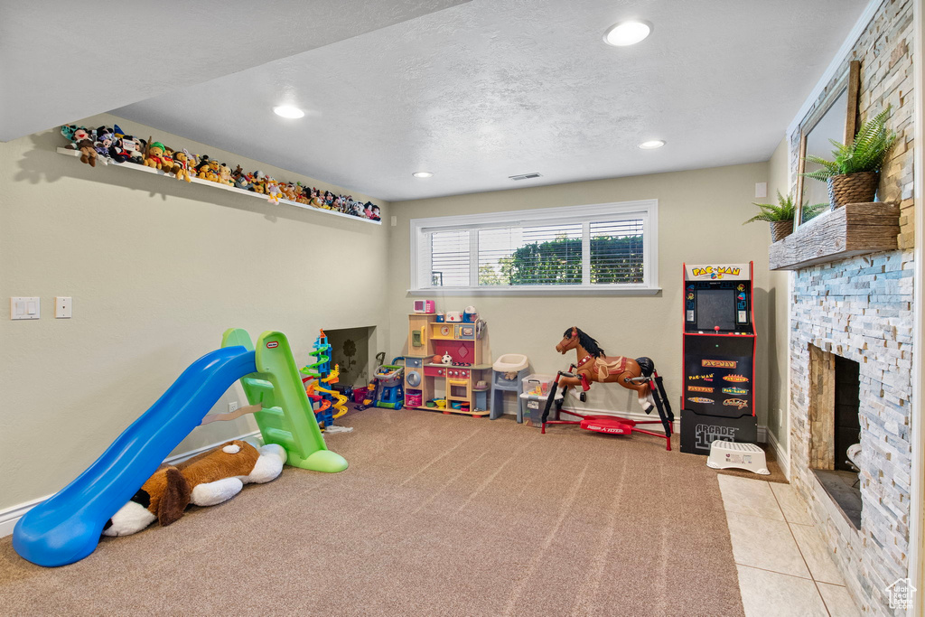 Playroom with recessed lighting and a stone fireplace