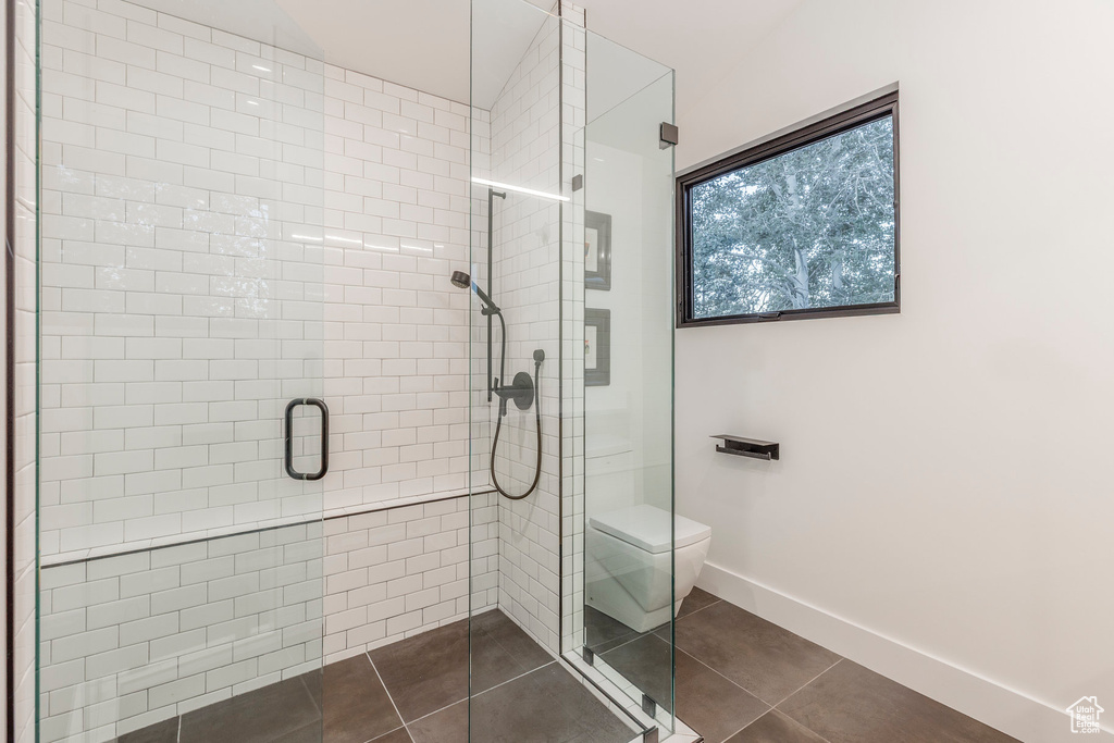 Bathroom with a stall shower and tile patterned floors