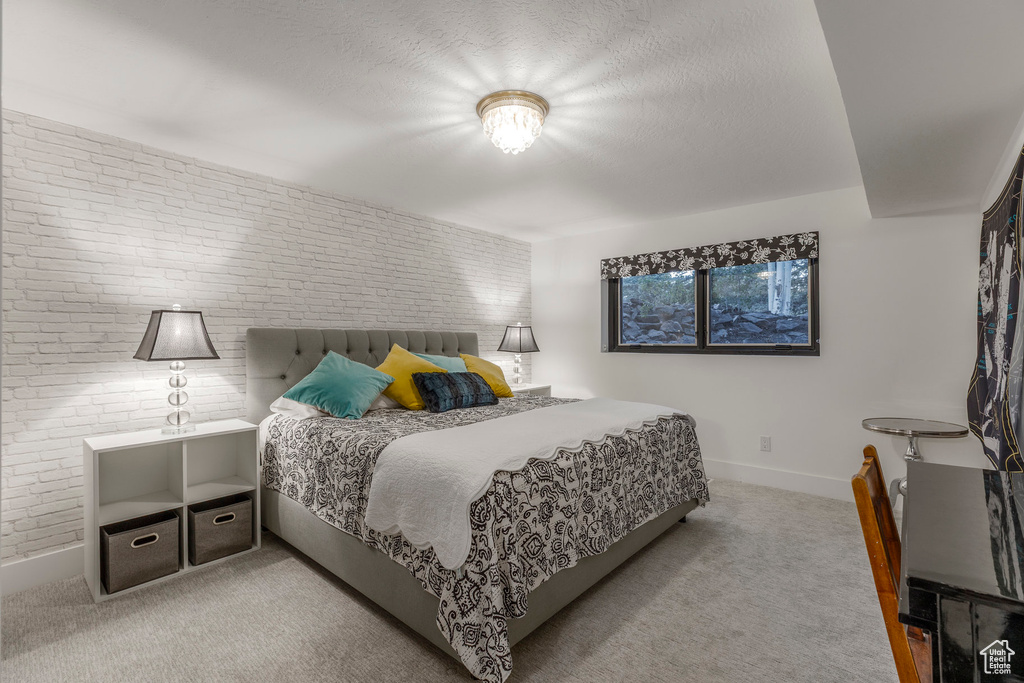 Bedroom featuring brick wall and carpet flooring