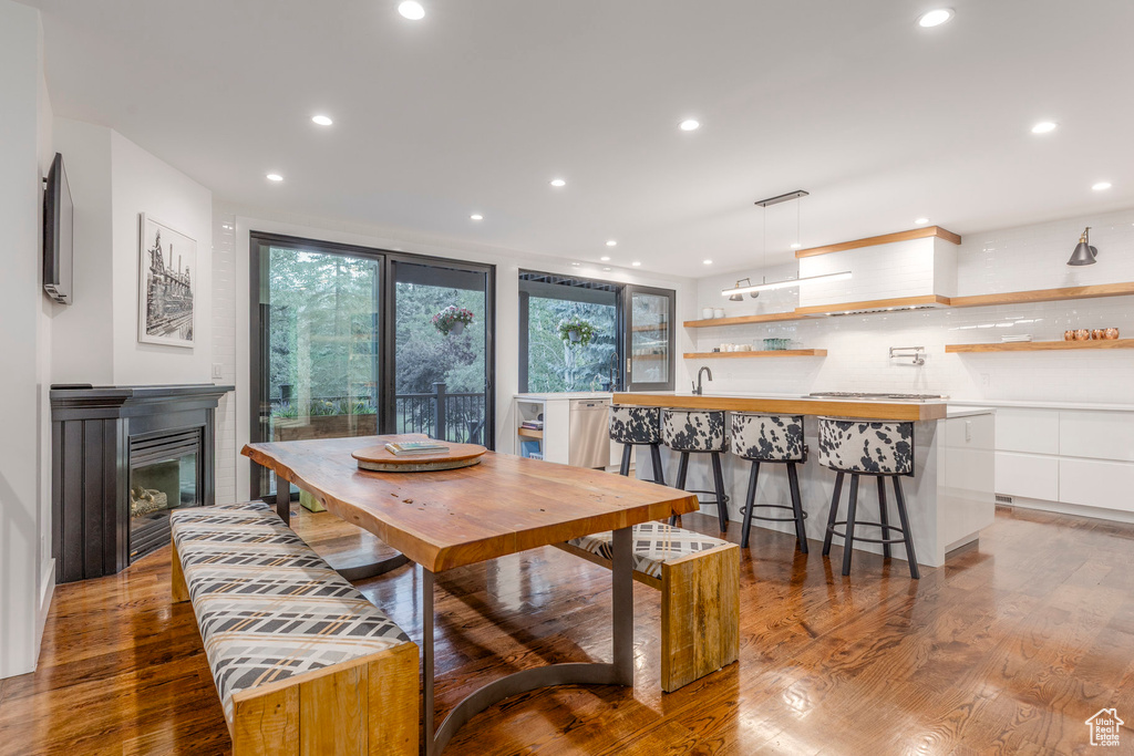 Dining area featuring recessed lighting, wood finished floors, and a glass covered fireplace