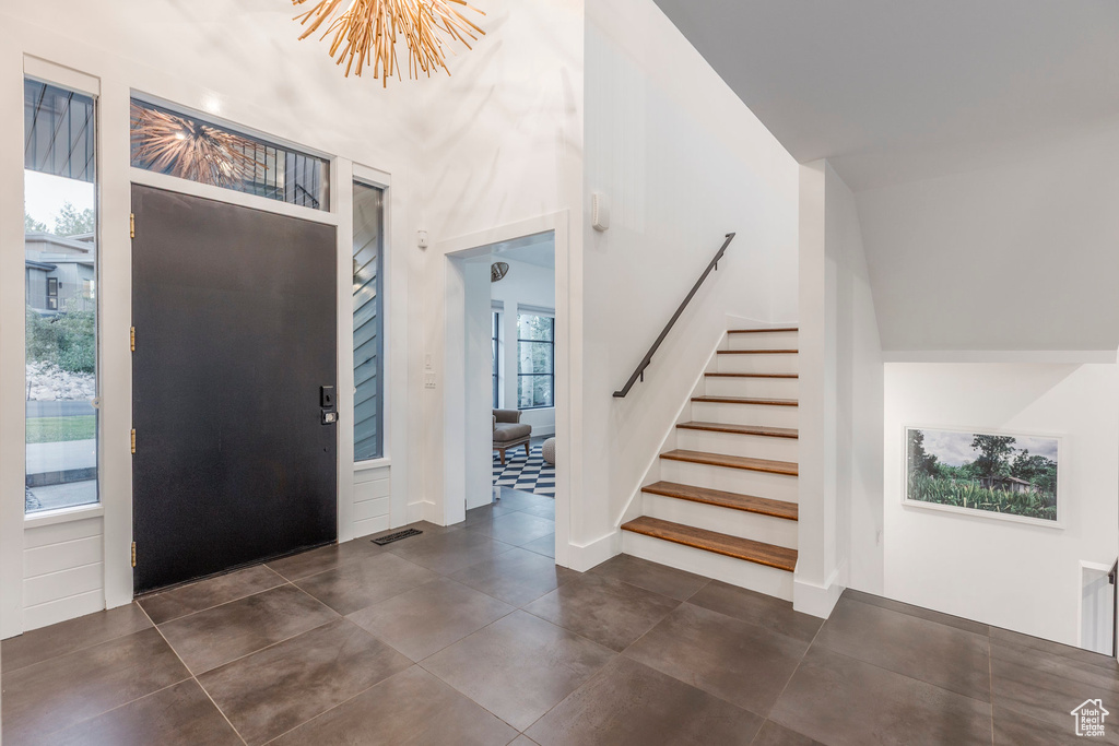 Foyer entrance featuring a chandelier and stairway