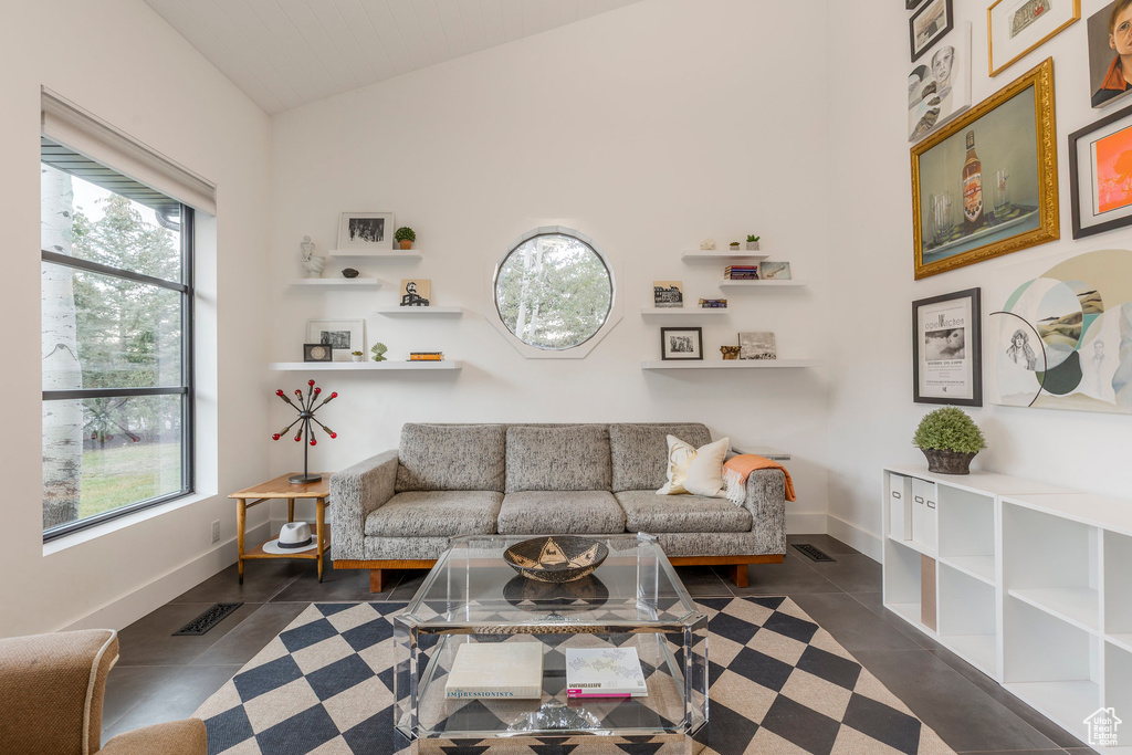 Tiled living room featuring vaulted ceiling and plenty of natural light