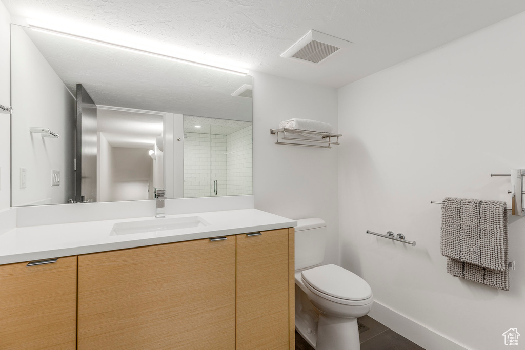 Bathroom featuring vanity, an enclosed shower, and tile patterned flooring