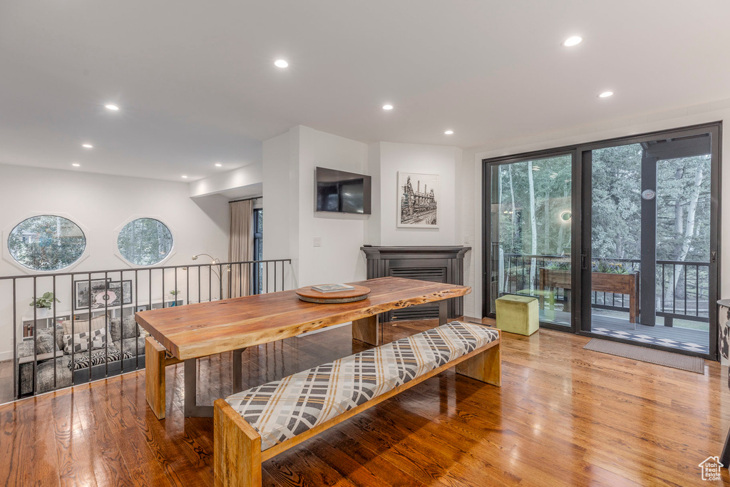Dining space with recessed lighting, wood finished floors, and a fireplace