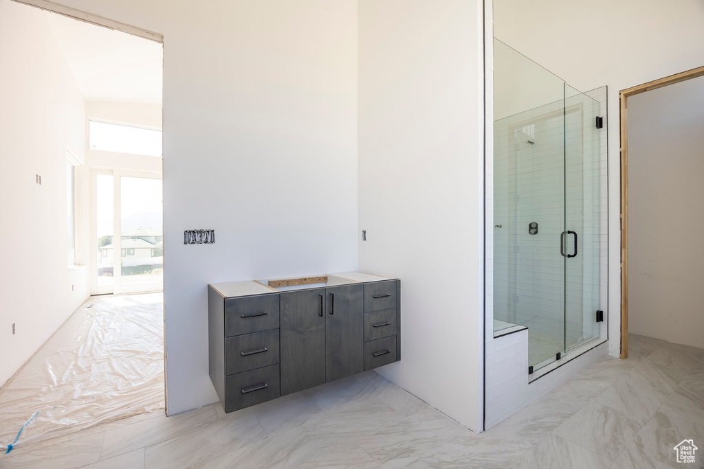 Full bathroom featuring a stall shower and marble finish floors