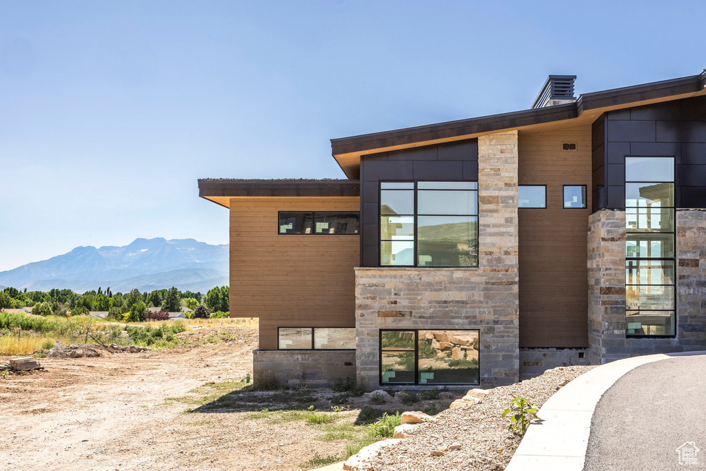 View of property exterior featuring stone siding and a mountain view