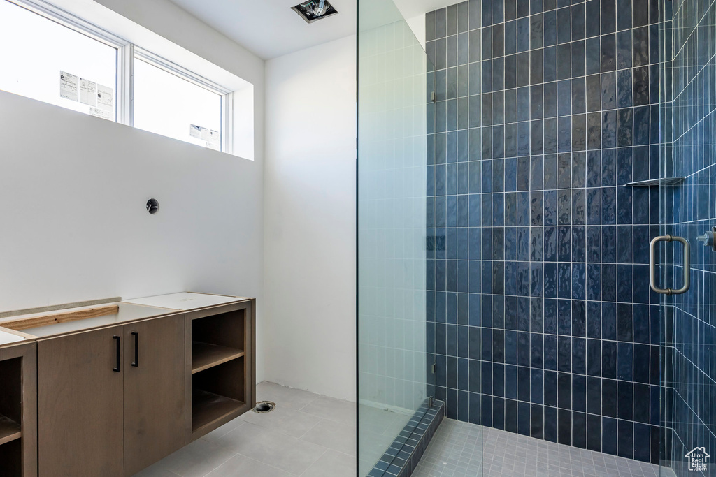 Bathroom featuring a tile shower and tile patterned flooring