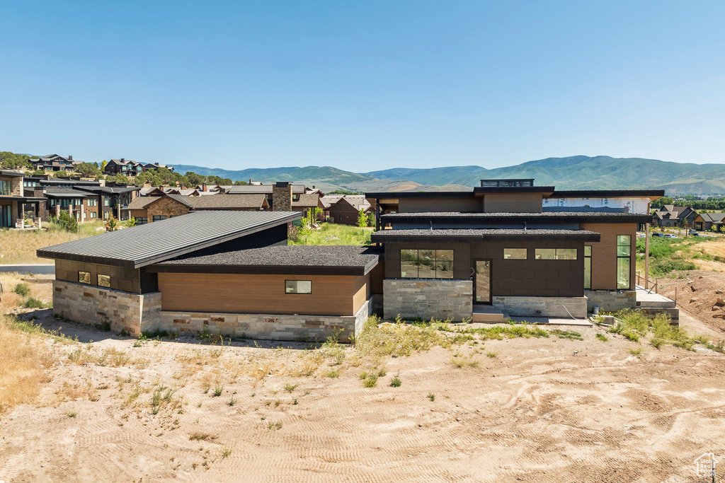View of home's exterior featuring stone siding, a mountain view, and a residential view