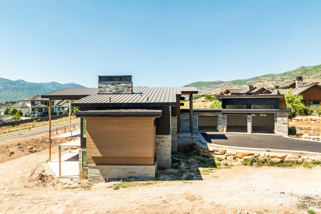 View of front of home with a mountain view, a standing seam roof, and a metal roof