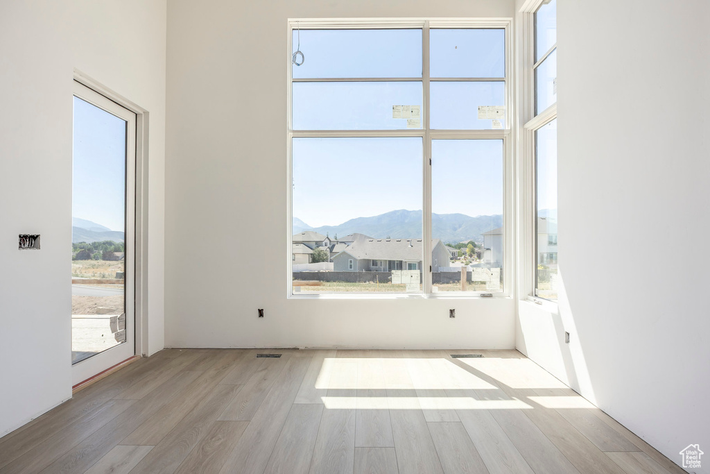 Spare room with a mountain view and wood finished floors