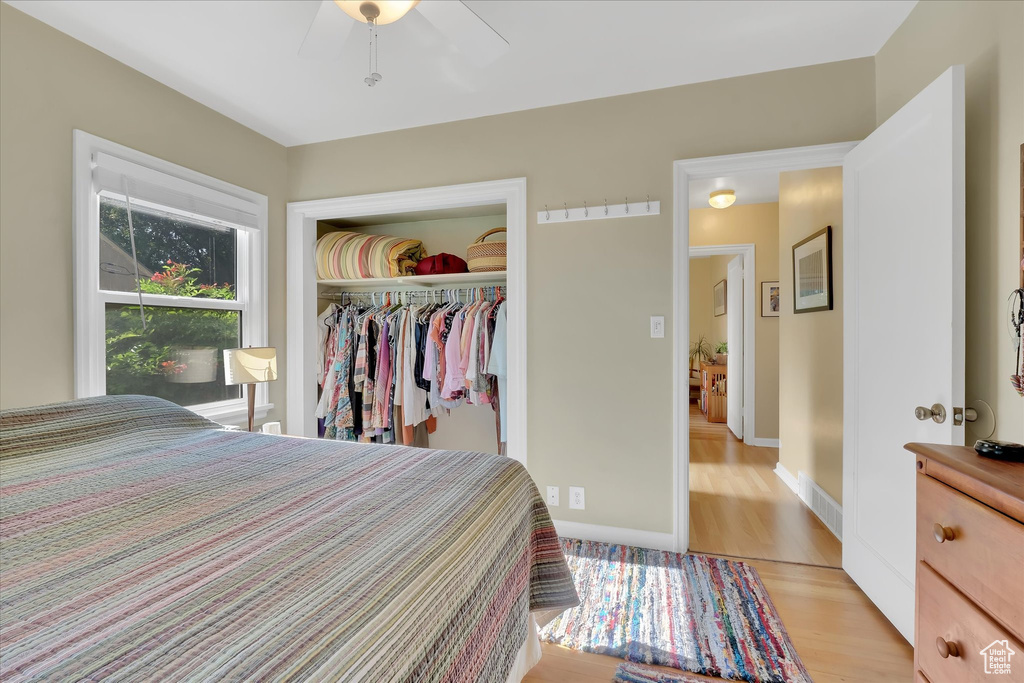 Bedroom featuring light wood-style floors, a closet, and a ceiling fan
