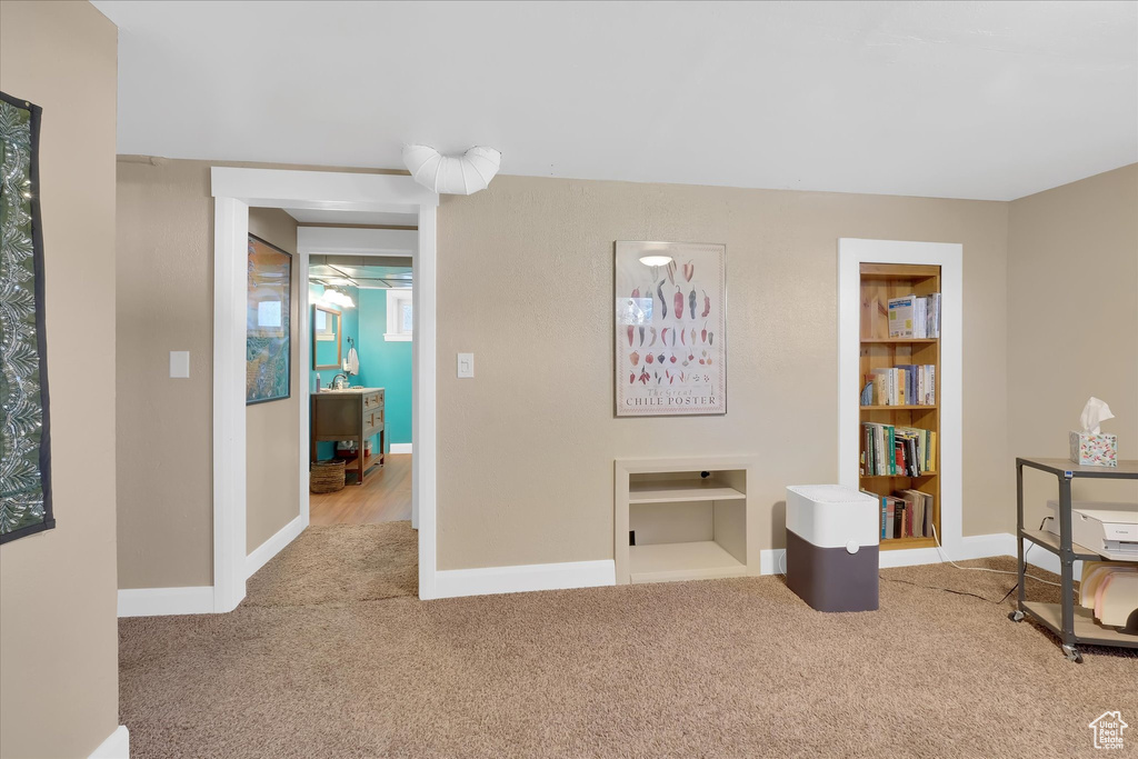 Sitting room featuring carpet and built in shelves
