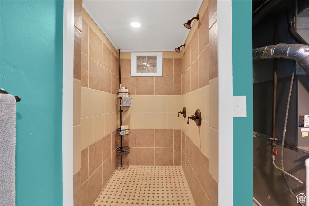Bathroom with a tile shower, heating unit, and recessed lighting