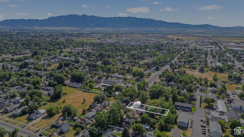 Aerial view of property and surrounding area with mountains and property parcel outlined