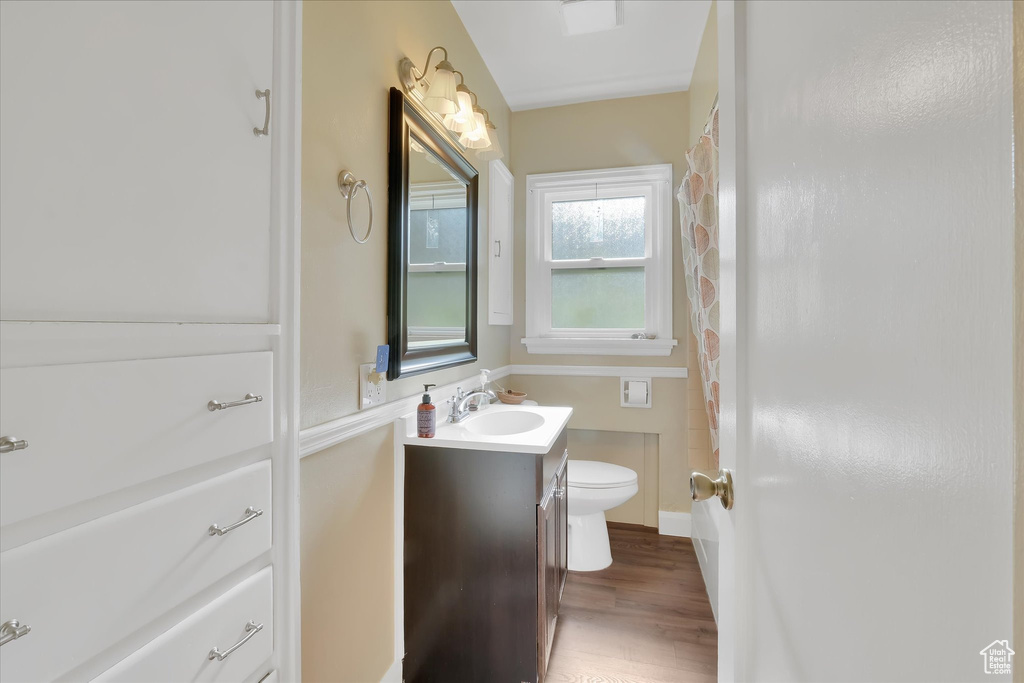 Full bath with vanity, wood finished floors, and shower / bath combination with curtain