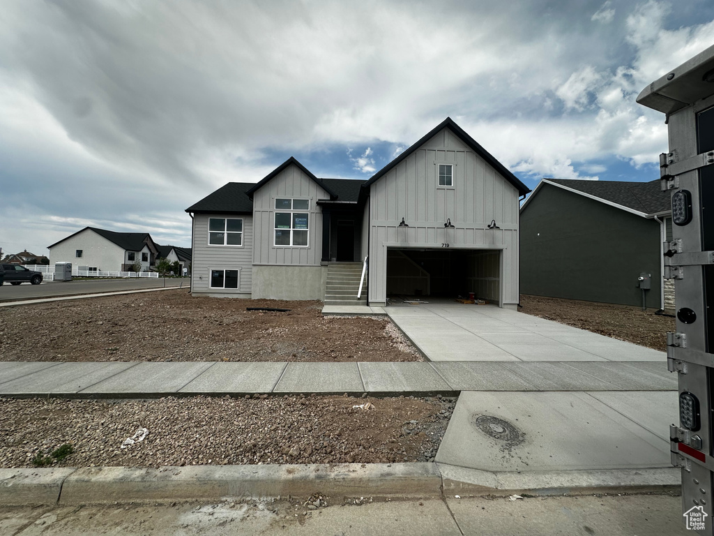 View of front facade featuring board and batten siding and driveway