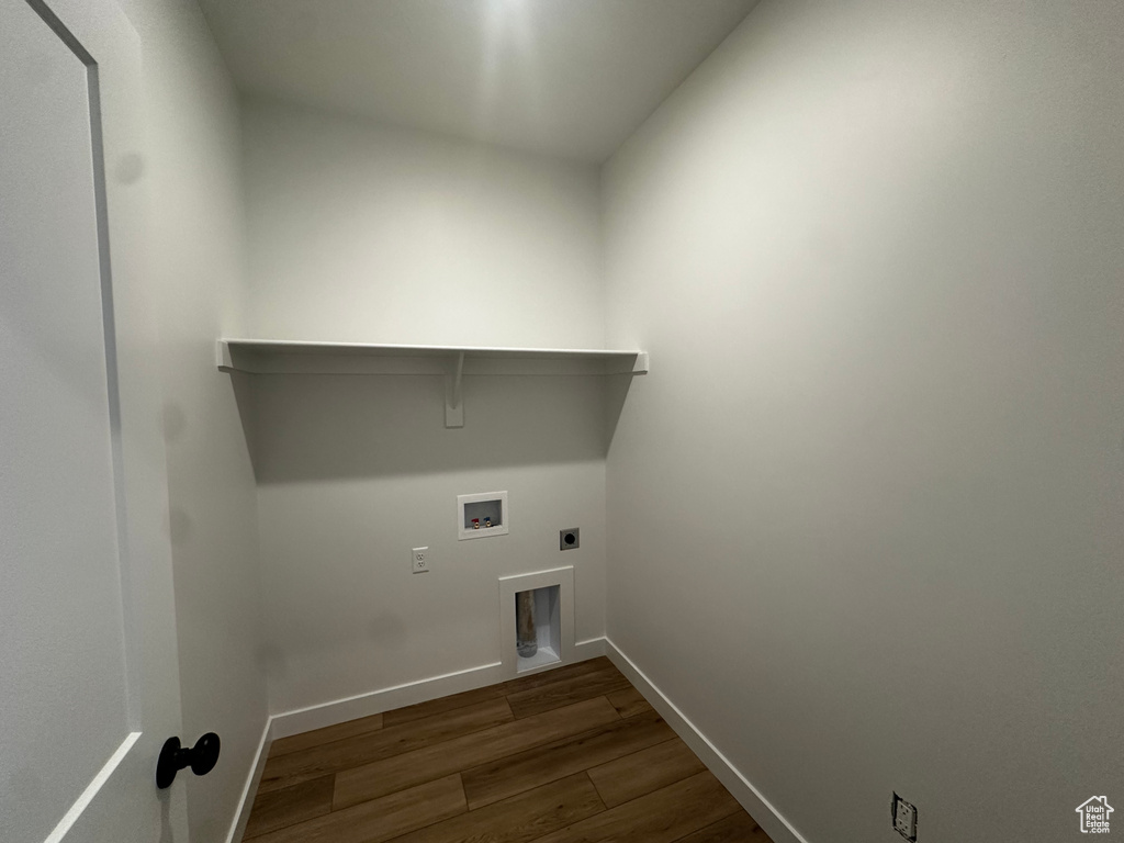 Laundry area with dark wood finished floors, hookup for an electric dryer, and hookup for a washing machine