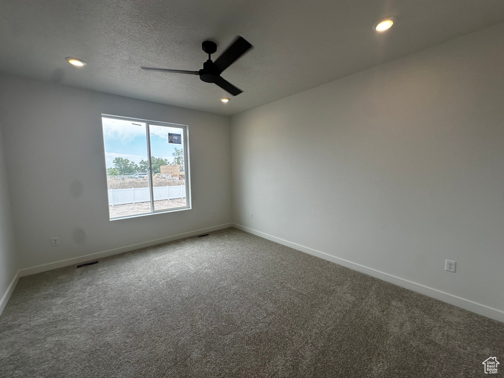 Carpeted empty room featuring a ceiling fan, recessed lighting, and a textured ceiling