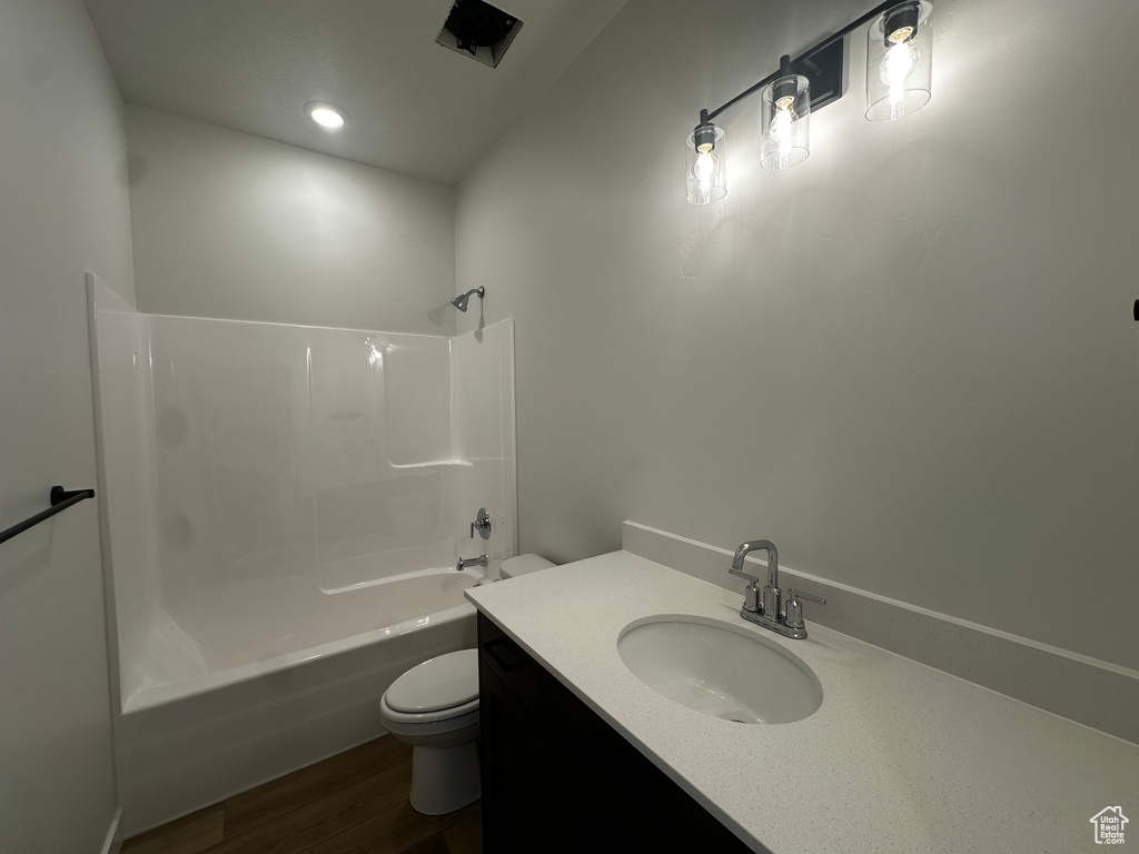 Full bathroom featuring  shower combination, vanity, and wood finished floors