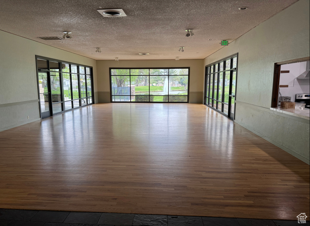 Spare room with wood finished floors and a textured ceiling