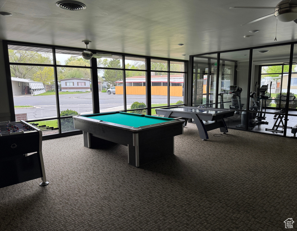 Playroom featuring ceiling fan, a wall of windows, carpet, and billiards