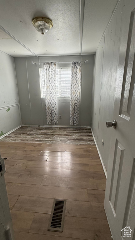 Spare room featuring wood-type flooring and baseboards